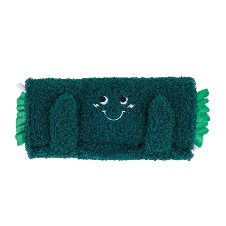 Green plush toy with a smiling face on a white background