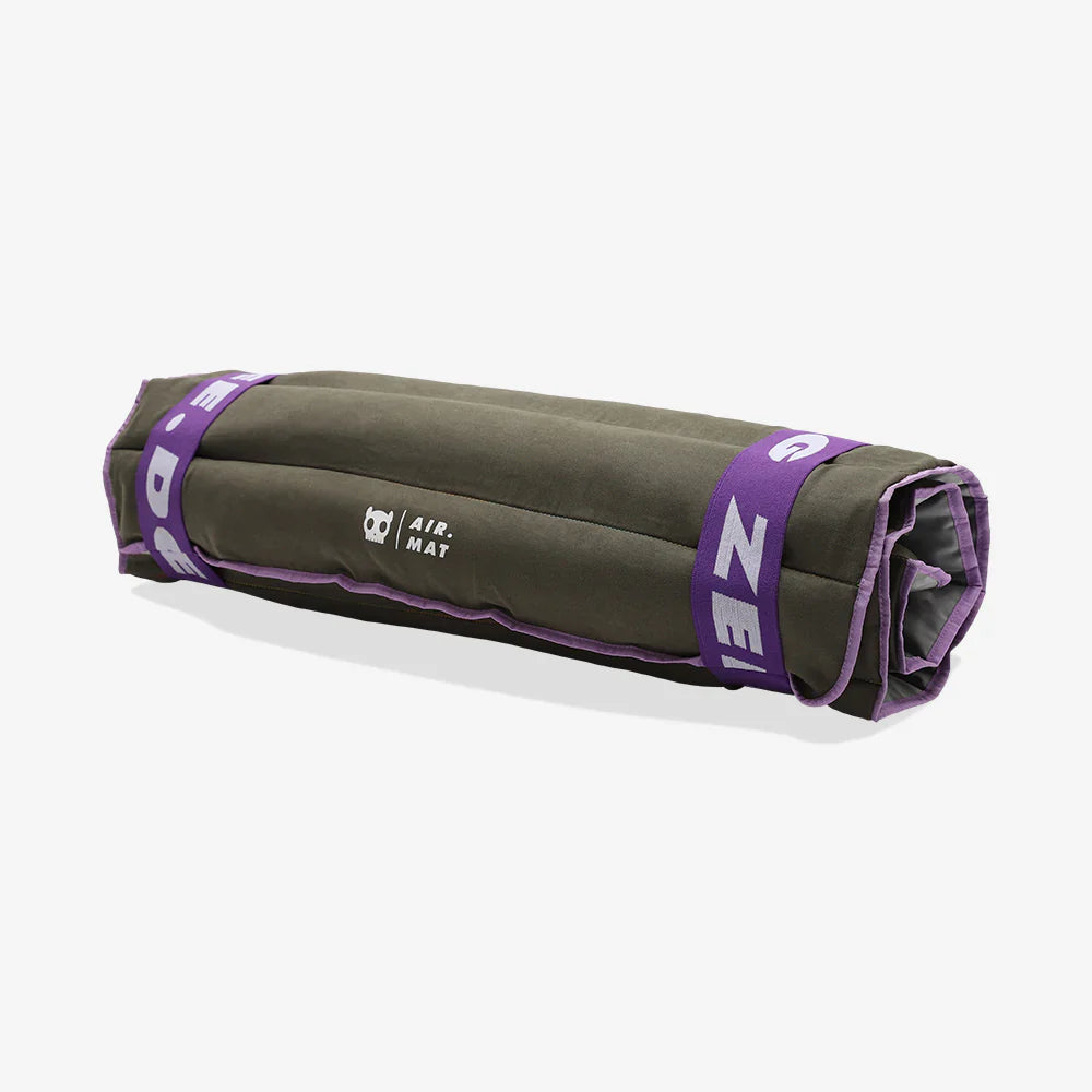 Roll-up air mat with purple straps on a white background