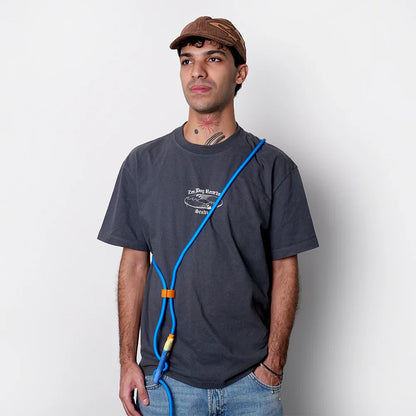 Man wearing a dark gray t-shirt with a graphic design, wearing saphire neopro handsfree leasha white background